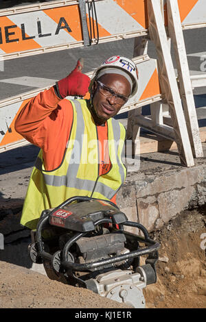 A construction worker working on underground piping using a compactor on Avenue of the Americas in the West Village in Manhattan, new York City. Stock Photo