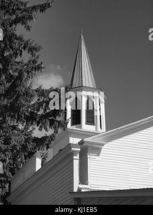 B&W old church and steeple against clear sky.