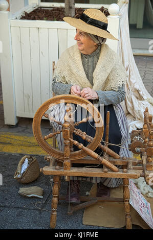 Live demonstration of an old woman using a wool spinning machine in Provence. Chesnut Festival of Cagnes sur Mer in French Riviera - November 2017 Stock Photo