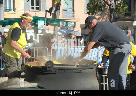 Two men preparing traditional Polenta on a provencal market.Chesnut Festival of Cagnes sur Mer in French Riviera - November 2017 Stock Photo