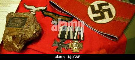 German Nazi armband, and medals as well as other insignia captured during the liberation of France in World war two. section from of Adolf Hitler's desk. Removed from the Fuhrer Bunker beneath the Chancellery in Berlin, by Lt Col Richard Broad MC, Seaforth Highlanders, The desk had been broken in pieces by Russian soldiers in May 1945, in World war two