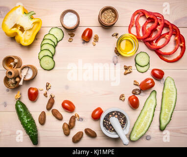 Superfoods and health or detox diet food concept cucumbers, bell peppers, cherry tomatoes, seasonings and herbs laid out on a white frame rustic woode Stock Photo