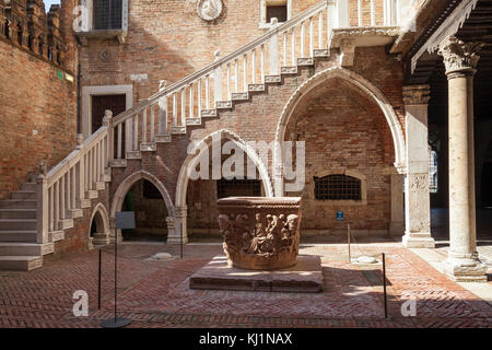 The courtyard of Ca D'Oro palazzo, Venice, Italy with the 1427 wellhead by Bartolomeo Don and staircase on lancet arches Stock Photo