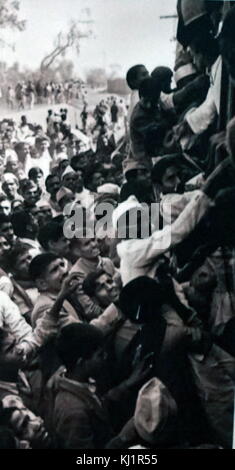 crowds travel to New Delhi, to watch the cremation of Mohandas Karamchand Gandhi 1869 – 1948), in 1948. Gandhi was the preeminent leader of the Indian independence movement in British-ruled India. At 5:17 pm on 30 January 1948, Gandhi was with his grandnieces in the garden of the former Birla House (now Gandhi Smriti), on his way to address a prayer meeting, when Nathuram Godse fired three bullets from a Beretta 9 mm pistol into his chest at point-blank range Stock Photo