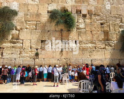 Women praying at the Western Wall, Wailing Wall or Kotel; an ancient limestone wall in the Old City of Jerusalem, Israel. The wall was originally erected as part of the expansion of the Second Jewish Temple by Herod the Great Stock Photo