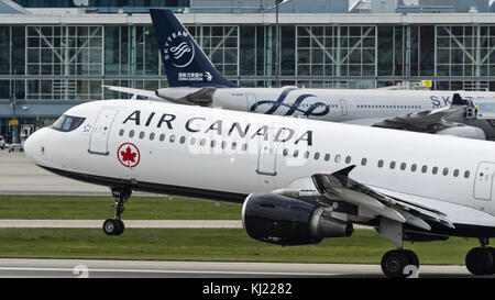 Richmond, British Columbia, Canada. 3rd Nov, 2017. An Air Canada Airbus A321-200 (C-GJWN) single-aisle narrow-body jet airliner, painted in the airline's new look livery, takes off from Vancouver International Airport. In the background a China Eastern Airlines Airbus A330 (B-5949) painted in Skyteam livery is docked at the airport's international terminal. Credit: Bayne Stanley/ZUMA Wire/Alamy Live News Stock Photo