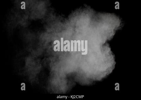 Launched white powder isolated on black background. Stock Photo