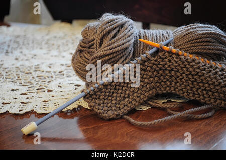 Clumps of yarn and knitting needles on the table Stock Photo