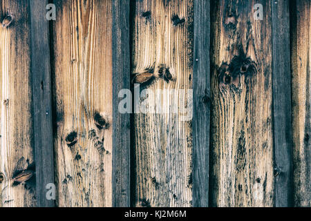 Vertical striped background from old faded boards. Wooden texture from brown vintage planks and laths with dark knots. Stock Photo