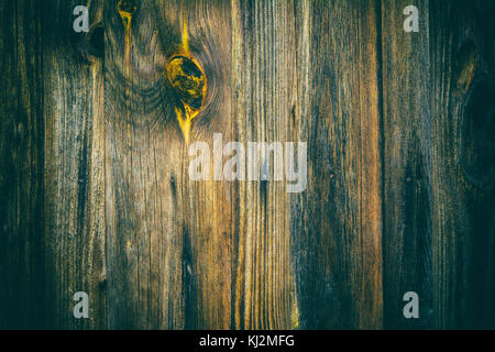 Dark grunge texture with vertical stripes of old boards. Background from wooden faded planks with decorative yellow knot. Stock Photo