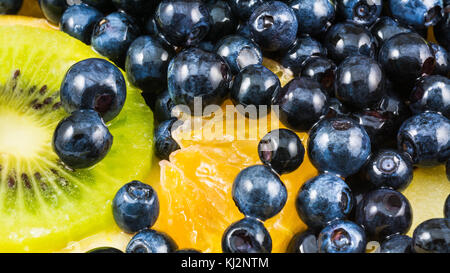 Delicious fruit salad with kiwi, orange and blueberries. Colorful background from the juicy fruit mix full of vitamins and antioxidants. Stock Photo
