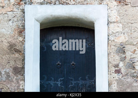 Old wooden door with forged hinges, wooden texture of old doors with forging elements Stock Photo