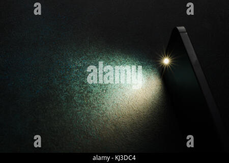 Lantern smartphone shines on a dark background. Stock Photo