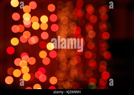 Christmas lights bokeh background. Orange, yellow and red lights on dark background Stock Photo