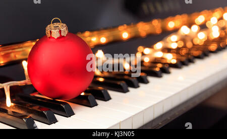 Christmas ball and lights on a classical piano keyboard, Stock Photo