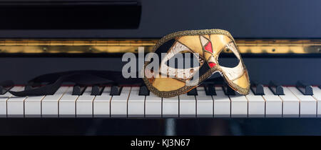 Carnival mask on classical piano keyboard, front view Stock Photo