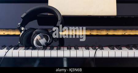 Headphones close up on piano keyboard, front view Stock Photo