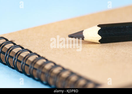 Notepad for drawing from recycled paper. On a spiral mount. A large pencil for sketching. Selective focus. Stock Photo