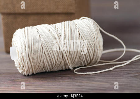 Hammer of a twine of a milk color on a wooden background top view, selective focus Stock Photo