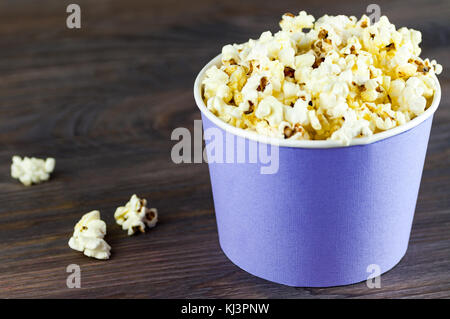 Popcorn in a bucket bucket is a top view on a dark wooden background. Macro shot from above Stock Photo