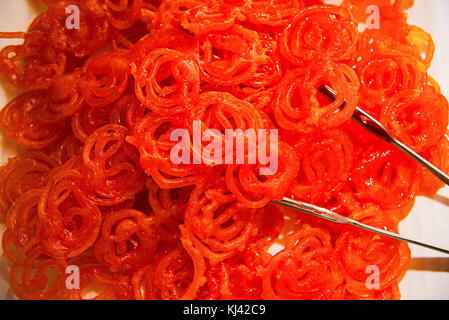 Close-up of Jalebi or zulbia sweet dish. Made by deep-frying maida flour batter in pretzel or circular shapes soaked in sugar syrup, Pune, Maharashtra Stock Photo