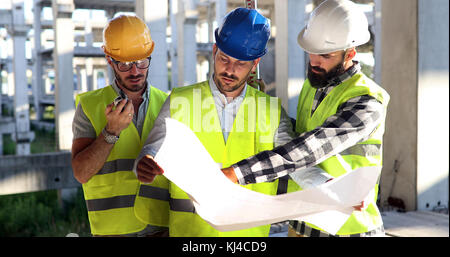 Construction engineers discussion with architects at construction site Stock Photo