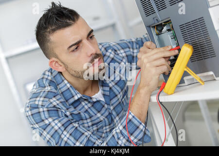 engineer using a voltage and current tester Stock Photo