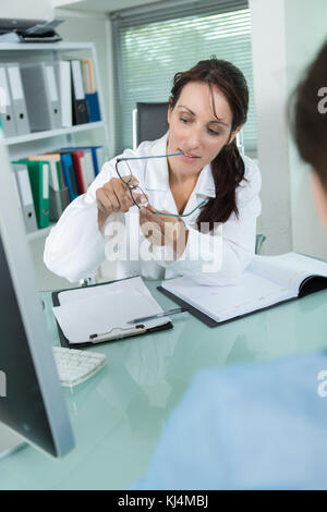 pretty optometrist holding glasses in clinic Stock Photo