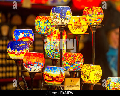 A display of coloured glass candle holders on display at a stall in the Edinburgh Christmas market. Stock Photo