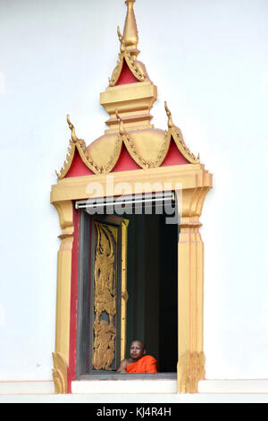 Buddhist monk at the window of a temple Vientiane , Laos Stock Photo