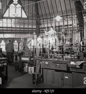 1950s, historical picture showing male research scientists working in the inorganic chemistry laboratory at Oxford University, a room with high ceilings built in the victorian gothic style. Stock Photo