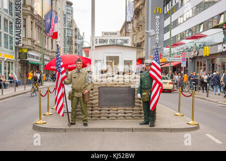 Checkpoint Charlie Berlin, two men holding American flags re-enact the roles of crossing guards at the Checkpoint Charlie tourism attraction in Berlin Stock Photo