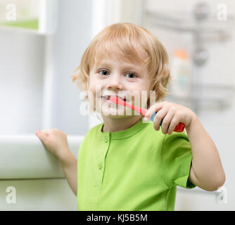 Little boy brushing his teeth in bathroom Stock Photo