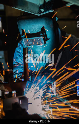 Worker is welding automotive part in car factory Stock Photo