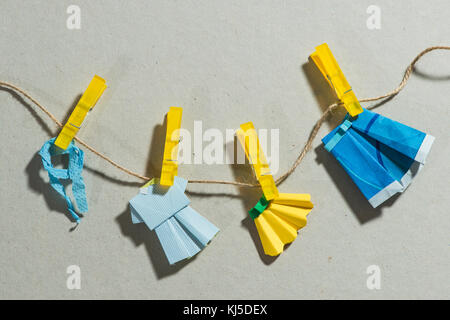 Origami clothes on laundry. Paper background Stock Photo