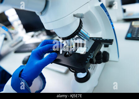Researcher conducting his research using a microscope Stock Photo