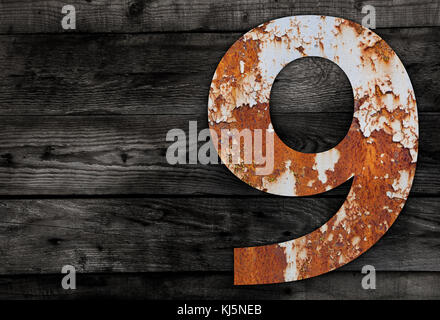 Old rusty metal alphabet, text 6 on Wooden Background nails. Stock Photo