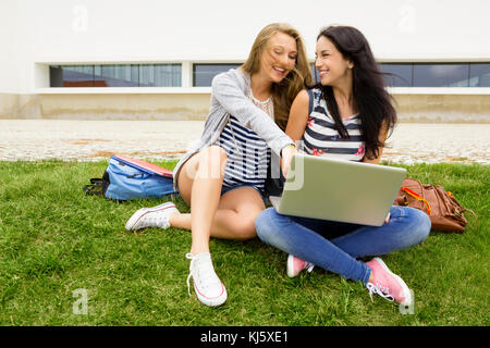 Tennage students sitting on the grass and study together with a laptop Stock Photo