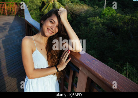 Young woman wearing white dress, on the outdoor urban park Stock Photo