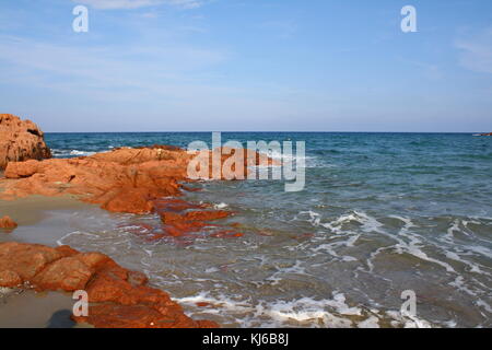 Waves coming in hard on the rocks and stones of a rigid beach seaside. Stock Photo