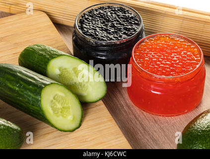 black and red caviar in a jar with vegetables Stock Photo