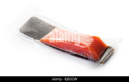 piece of red fish in vacuum packing on white isolated background Stock Photo