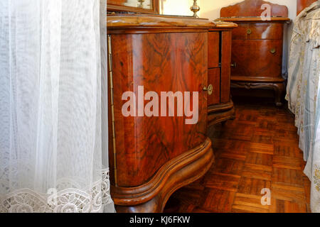 Small couch in the bedroom. Italian wood furnishings. Italy Europe Stock Photo