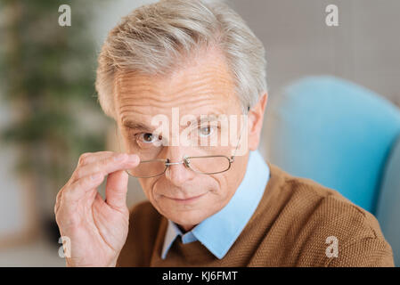 Confident old man wearing glasses looking into the camera Stock Photo