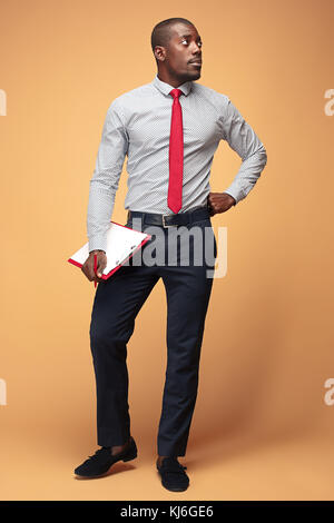 Attractive standing Afro-American businessman writing notes Stock Photo