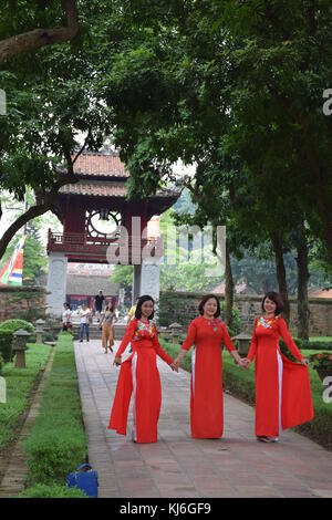 Three beautiful vietnamese women dressed in red posing for a photo shoot inside temple of literature in Hanoi, Vietnam Stock Photo