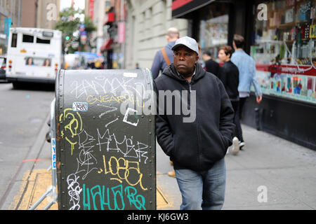 NEW YORK CITY, NY, USA - OCTOBER 2017 - Unidentified man standing and lean over a trash can in Manhattan Stock Photo