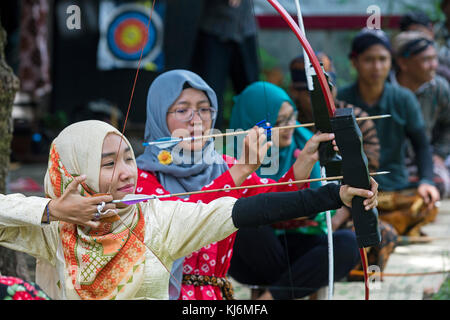 Indonesian girls practicing Jemparingan / traditional Javanese archery by shooting bow and arrows in the city Yogyakarta, Java, Indonesia Stock Photo