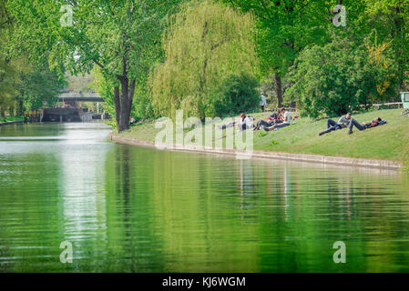 Berlin River, view of young German people relaxing on the banks of the Landwehrkanal on a spring afternoon in the Tiergarten park, Berlin, Germany. Stock Photo