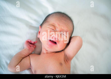 Newborn baby crying on the bed, selective focus Stock Photo